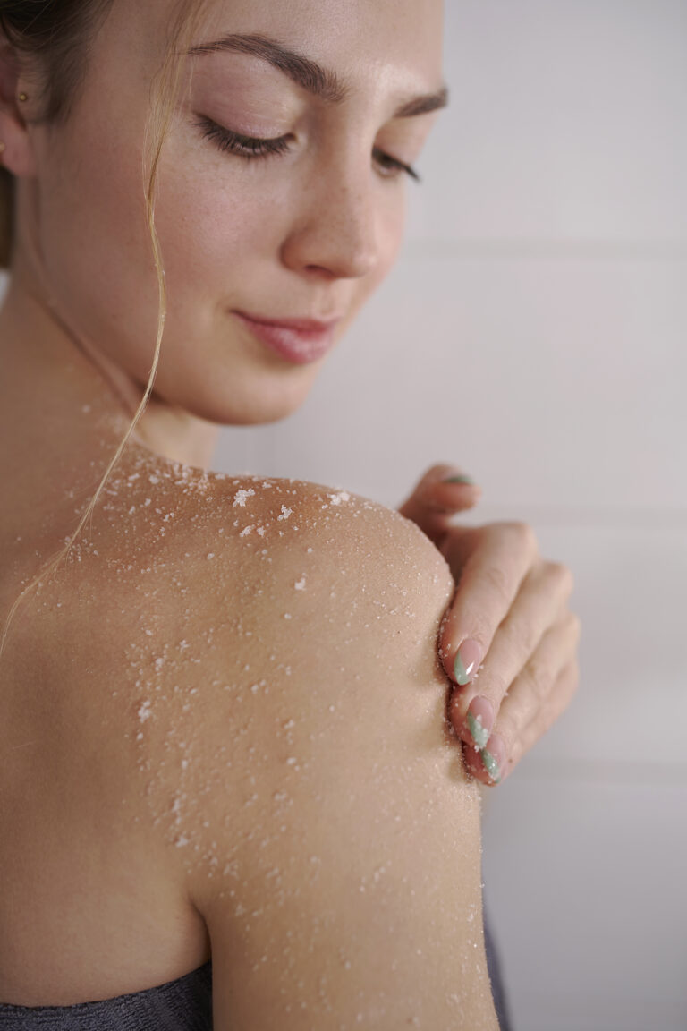 Woman applying Magrada Organic Cosmetics lavender body scrub on her shoulder for gentle exfoliation