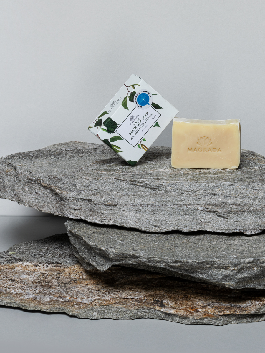 Magrada Organic Cosmetics Nordic birch sap soap bar and its packaging placed on layered gray stones