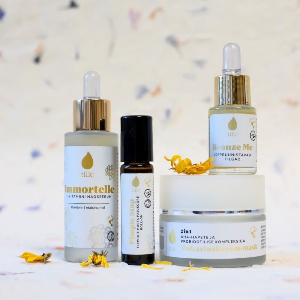 Tilk skincare set including Immortelle vitamin C serum, Bronze Me self-tanning drops, and 2-in-1 AHA probiotic cream mask with yellow flowers