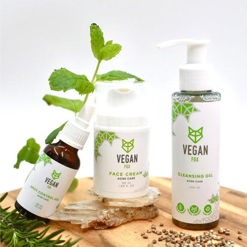 Vegan Fox acne care face set with spot control oil, face cream, and cleansing gel on wooden surface with green leaves