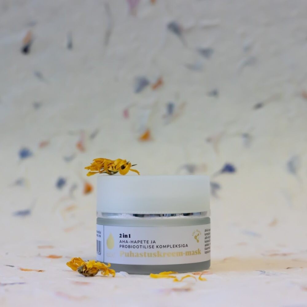 Tilk 2-in-1 cleansing cream mask in white jar with yellow flower petals on top and around
